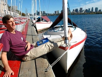 David Kessler, who works at MIT Sloan School of Management, breaks into song down at the Sailing Pavilion on Friday, Oct. 21. Kessler, who helped launch a series of sea chantey sings, is holding a book of sea chanteys.