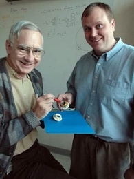MIT physics Professor David E. Pritchard, left, and James K. Thompson display the key part of the apparatus they used to check Einstein's most famous equation. Their test was 55 times more accurate than previous tests.