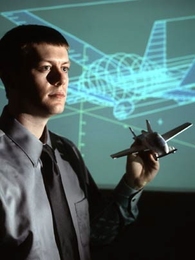 Carl Dietrich, 2006 winner of the $30,000 Lemelson-MIT Student Prize, holds a model of the personal air vehicle that he envisions for use in the air and on the road.
