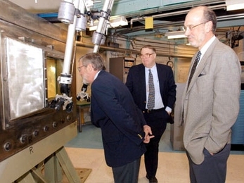 Nuclear Regulatory Commissioner Peter Lyons peers into a 'hot cell' (a shielded room where radioactive materials can be handled remotely) on a tour of the nuclear reactor on Tuesday, Feb. 28. At center is John Bernard, director of reactor operations at the MIT Nuclear Reactor Laboratory, and at right is David Moncton, director of the Nuclear Reactor Lab.