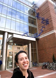 Sculptor Sarah Sze stands outside the Sidney-Pacific graduate student residence on Friday, March 17. Her new work, 'Blue Poles,' can be seen behind her, running up the side of the building.