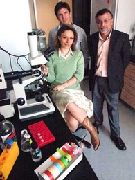 Three members of the team that found growth factor prevents the effects of visual deprivation in the brain pose in the lab. They are: Daniela Tropea, a postdoctoral fellow at the Picower Institute for Learning and Memory, seated; Gabriel Kreiman, a postdoctoral fellow with the McGovern Institute for Brain Research; and Mriganka Sur, head of the Department of Brain and Cognitive Sciences at MIT.