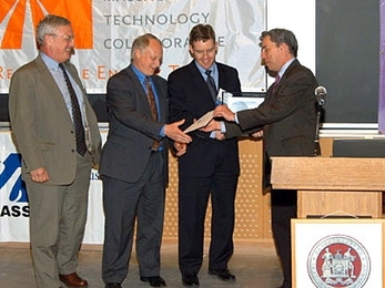 Warren Leon presents the top prize in the 2006 Ignite Clean Energy Business Presentation Competition to representatives of Stellaris, from left, Jim Paull, president and co-founder; Tom Ward, vice president; and Lee Johnson, chief operating officer and co-founder.