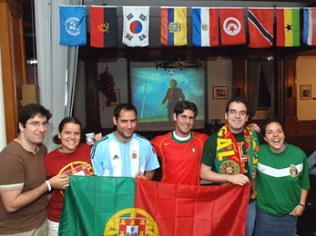 Soccer fans gather at Ashdown House for the World Cup first-round match between Portugal and Mexico held June 21. From left are Jorge Almeida and Clara Barata, both Harvard graduate students; new MIT graduate Reimundo Heluani; Marcus Dahlem, graduate student in EECS; Joao Castro, ESD graduate student; and Alejandra Menchaca, aero-astro graduate student. Menchaca was the only one in this group root...