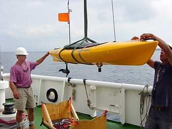 MIT research engineer Joseph Curcio, left, helps launch a SCOUT for experiments conducted off the island of Pianosa, Italy, in July 2005.