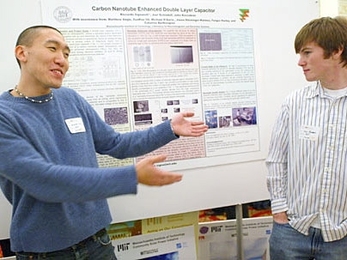 Senior Andrew Lee welcomes sophomore Dan Rogers to a presentation on carbon nanotube capacitors.