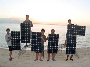 First Step Coral team members hold SunPower solar panels to make "MIT" sign at sunset in Sagay, Philippines. Left to right: Martin Lorilla '09, Illac Diaz (MIT SPURS Fellow), Emzo de los Santos '09, Francis Lorilla (MIT Dad) and Gerardo Jose la O' (MIT graduate student).
