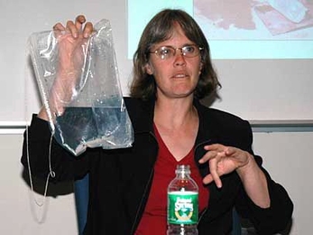 Amy Smith displays a bag, designed in part by one of her students, that is used in a simple water disinfection process. The bag is patented, but can be distributed free in Third World countries.