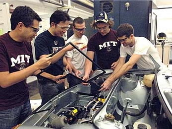 Left to right: Gerardo Lao, grad student in material science, Emmanuel Sin, mechanical engineering senior, Ryan King, mechanical engineering sophomore, Jeremy Kuempel, freshman in mechanical engineering, Craig Wildman, graduate student in mechanical engineering team around the porsche in Sloan Automotive Lab. They are installing batteries in the front trunk compartment of the vehicle.