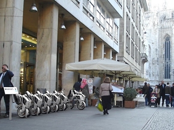 The low cost and foldable design of these electric scooters, as shown in this rendering outside the Duomo in Milan, could provide a convenient and efficient mode of transportation in urban environments.