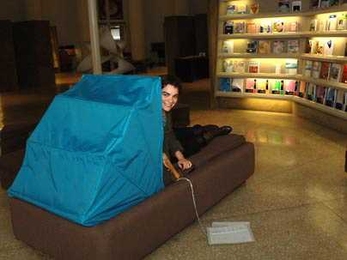 Sofia Ponte, an MIT graduate student in architecture, peers around the  canopy of Dreaming Lounge, on display in Barker Library through Feb. 15. Ponte created the furniture prototype for what she hopes will be a refuge for students needing respite from too much analytical thought.