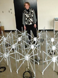 Physics professor Jacqueline Hewitt, director of MIT's Kavli Institute for Astrophysics and Space Science, stands behind a prototype of a radio telescope array. A team she leads has been chosen by NASA to develop plans for such an array on the far side of the moon.