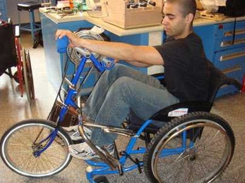 James Levi Schmidt, a member of an MIT class on wheelchair design for the developing world, tests a prototype of a wheelchair that was converted into a tricycle powered by hand-operated pedals.