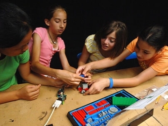 Students from the O'Maley Middle School in Gloucester, MA put together "insect robots" and learn how to make them move with light and touch using computer sensors at the Edgerton Center at MIT. From left are Qiana Curcuru, Kelly Foster, Casie Quinn and Justina Catarino.