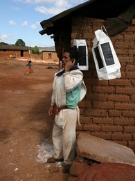 Portable Light textiles charge in the sun in a Huichol village in the Tateikie region of the Sierra Madre, Mexico. A Huichol man in the Sierra Madre uses a Portable Light textile to charge his cell phone and place a call to check market prices.