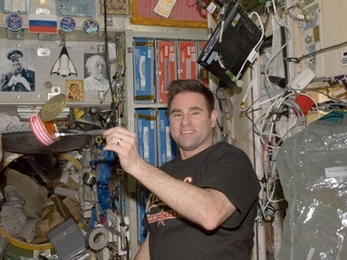 NASA Astronaut Greg Chamitoff PhD '92 catches a meal near the galley of the International Space Station. Michael Fincke '89 will be joining him shortly.