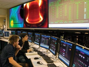 From the control room, graduate students Rachael McDermott and Eric Edlund perform experiments on the Alcator C-Mod tokamak to support their thesis work.