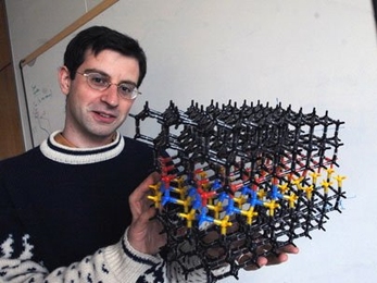 Mechanical Engineering Professor Tonio Buonassisi holds model illustrating problems with solar cells he is working on (in blue).