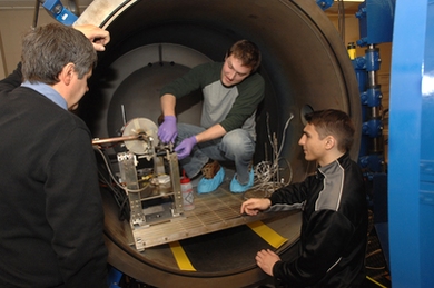 Department of Aeronautics and Astronautics graduate student Taylor Matlock, center, principal research scientist Oleg V. Batishchev, left, and Dan Stiurca, junior in electrical engineering and computer science, right, work on adjusting a prototype of a new plasma rocket.