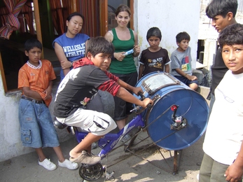 MIT students and residents of Ventanilla, Peru work on the bicilavadora, a novel, inexpensive bike/washing machine.