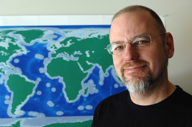 Professor of Anthropology and author of "Alien Ocean" Stefan Helmreich by a map showing  areas where the microbes his subjects study proliferate.