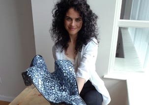 Neri Oxman poses in her studio with a model of a molded chaise longue that drew inspiration from the internal structure of bones and other biological forms.