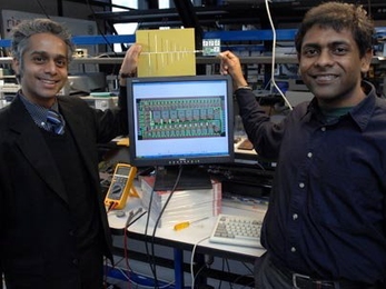 Associate Professor of Electrical Engineering Rahul Sarpeshkar, left, and Soumyajit Mandal display their RF (radio frequency) cochlea, a low-power, ultra-broadband radio chip. The chip, held by Mandal, is attached to an antenna, held by Sarpeshkar. The diagram on the computer monitor shows the wiring layout of the chip.