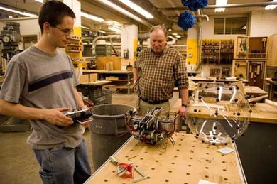 MIT student Greg Schroll '08 works with Hobby Shop Director Ken Stone '72 on his award-winning spherical robot.
