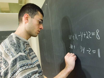 Avinatan Hassidim, a postdoc in the Research Laboratory of Electronics, writes out a system of four linear equations with four variables. The quantum algorithm that he, Seth Lloyd, and Aram Harrow devised can solve systems with a trillion equations and a trillion variables.