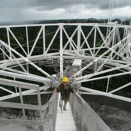 Joe Davis ascends a walkway from the transmission dome suspended 500 feet above the Arecibo radiotelescope dish in Puerto Rico, after his transmission of a message to alien beings.