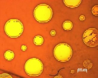 To test a new technique for creating micromachines, MIT researchers deposited films of gold on a sheet of plastic; grooves in the plastic are visible as a series of horizontal lines.