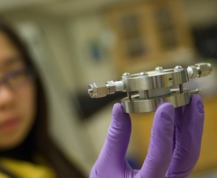 Doctoral student Yi-Chun Lu holds an experimental lithium-air battery that was used for testing at MIT.