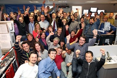 Celebration after the highest energy collisions ever created took place at the LHC, after a few decades of preparation. Pictured are the collaborators from around the world forming the operations crew in the CMS control room, including MIT post-doc Erik Butz (right foreground, in striped shirt) and graduate student Pieter Everaerts (third row back on the left, brown sweater) who were present as "e...