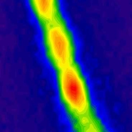 This filament containing about 30 million carbon nanotubes absorbs energy from the sun as photons and then re-emits photons of lower energy, creating the fluorescence seen here. The red regions indicate highest energy intensity, and green and blue are lower intensity.