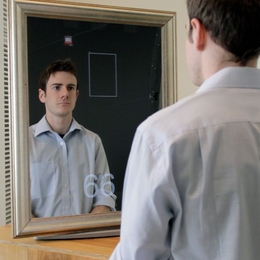 MIT Media Lab student Daniel McDuff, who collaborated on the pulse-monitoring system, demonstrates a version of the device built into a mirror that displays his pulse rate in real-time at the bottom.