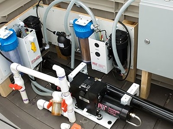 In the system, a solar photovoltaic panel powers pumps that push seawater through a permeable membrane to remove salt and other minerals.