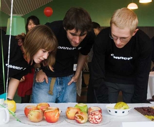 Freshman Caitlin Sample, left, sophomore Andras Kiss and freshman Brandon Lowe check out the entries in the category “Apple Art.” 