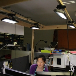 Visiting student Nan Zhao works in the test setup at the Media Lab under four LED fixtures controlled by the prototype adaptive system.