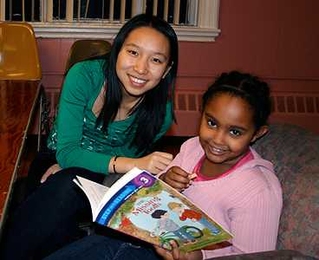 MIT senior Yue Li assists a child at the Cambridge Community Center in increasing her literacy skills via the ReachOut: Help Teach a Child to Read program.