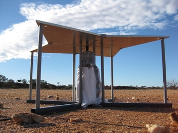 Close up of the EDGES antenna. The four panels are made from aluminum sheet metal and supported by PVC legs. The white bag under the antenna encloses analog amplifiers and calibration circuits.