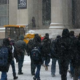 Students trek through a snowy MIT campus.