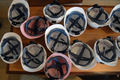 A table full of construction helmets and safety goggles awaits a tour group. Because Maseeh Hall is still under construction, participants were required to wear safety gear.