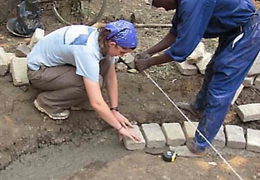 EWB's Tess Saxton-Fox, a junior in mechanical engineering, helps lay the foundation for the village's new rainwater harvesting tank.