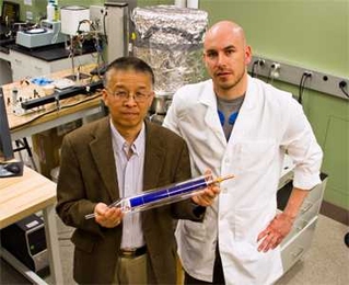Doctoral student Daniel Kraemer, right, and Professor Gang Chen display a prototype of a flat-panel solar-thermoelectric generating device.