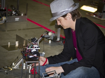 Junior Kelsey Brigance takes a look at one of the two robots she utilized in the competition.
