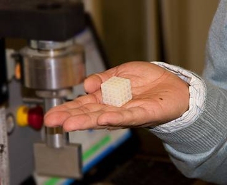 A sample of a co-continuous polymer composite material produced in the lab by a team including MIT postdoctoral researcher Lifeng Wang. Device in background is used to test the strength of the material.
