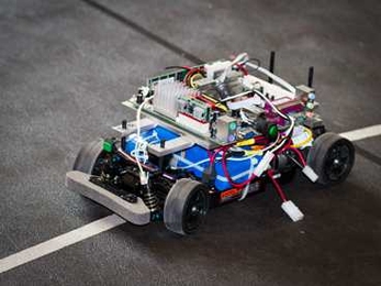 The researchers test their algorithm using a miniature autonomous vehicle traveling along a track that partially overlaps with a second track for a human-controlled vehicle, observing incidences of collision and collision avoidance.