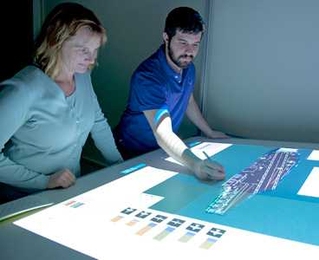 Missy Cummings and student Jason Ryan work on a virtual planning tool designed to organize planes and personnel on aircraft carrier deck.