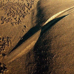 A view looking southeast along the surface trace of the San Andreas fault in the Carrizo Plain. In this image, a road has been cut going through the fault (from left to right).