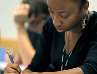 A student writes while at desk